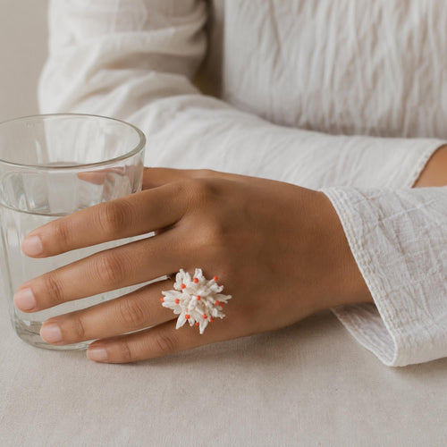 model wearing the handcrafted white shiuli ring, made joining several tiny fabric flowers.