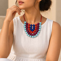 Model wearing the handcrafted fabric beaded Anokhi neckpiece in colors of blue, purple, orange