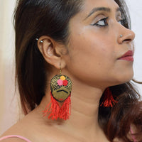 model wearing a pair of Frida Kahlo inspired handmade and handembroidered hook earrings.