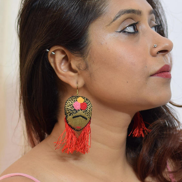 model wearing a pair of Frida Kahlo inspired handmade and handembroidered hook earrings.