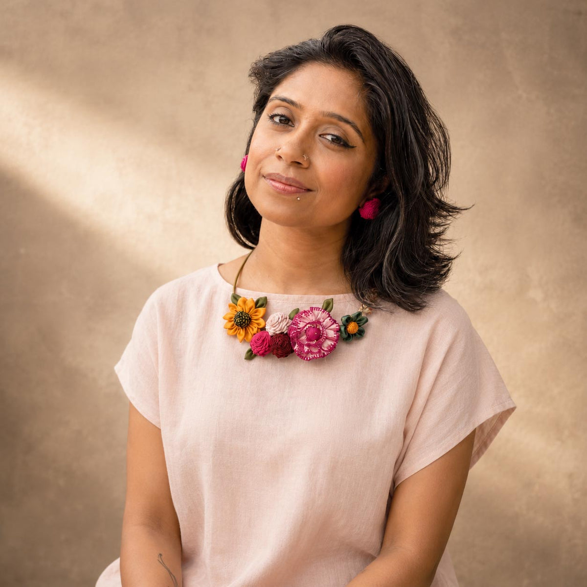 a model wearing a handcrafted floral Metal neckpiece, Gul Hasli that sits around her neck closely.