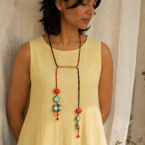 A woman wearing an adjustable handmade fabric Julie neckpiece.