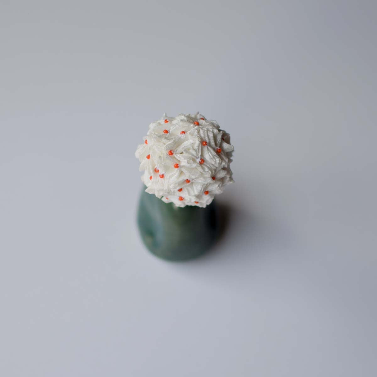 Top shot of the Shiuli handcrafted hair accessory to show the tiny fabric flowers all stitched together to form one beautiful hair accessory.