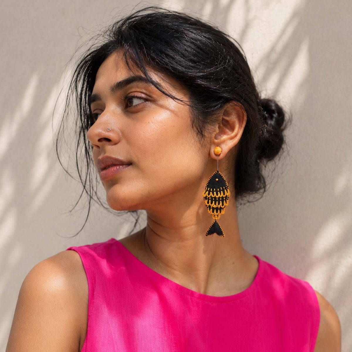 Model wearing black Rui handmade fish-inspired textile stud earrings By Paulami Saha