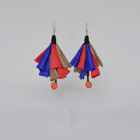 A pair of multicolored fabric earrings with hooks, featuring red, blue, and brown patches.