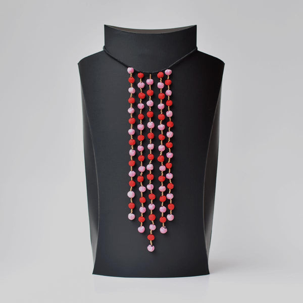 A colorful beaded neckpiece displayed on a black mannequin bust